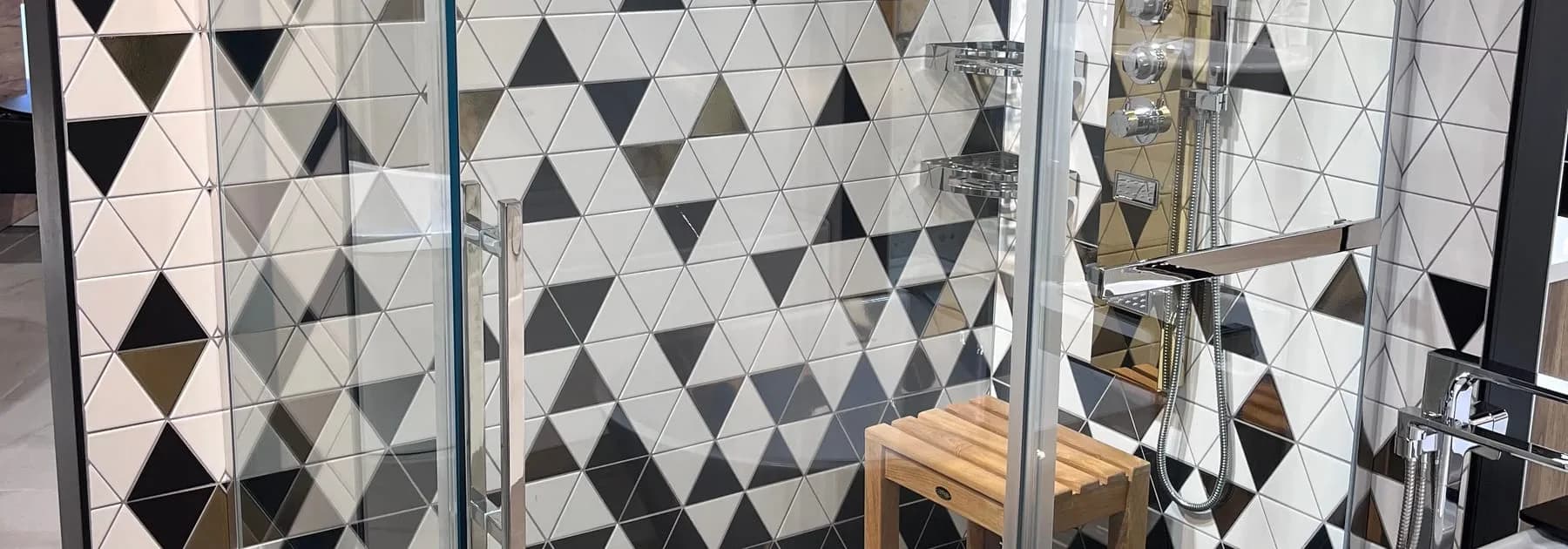 Douche vitrée devant une céramique à motifs de triangles noirs et blancs