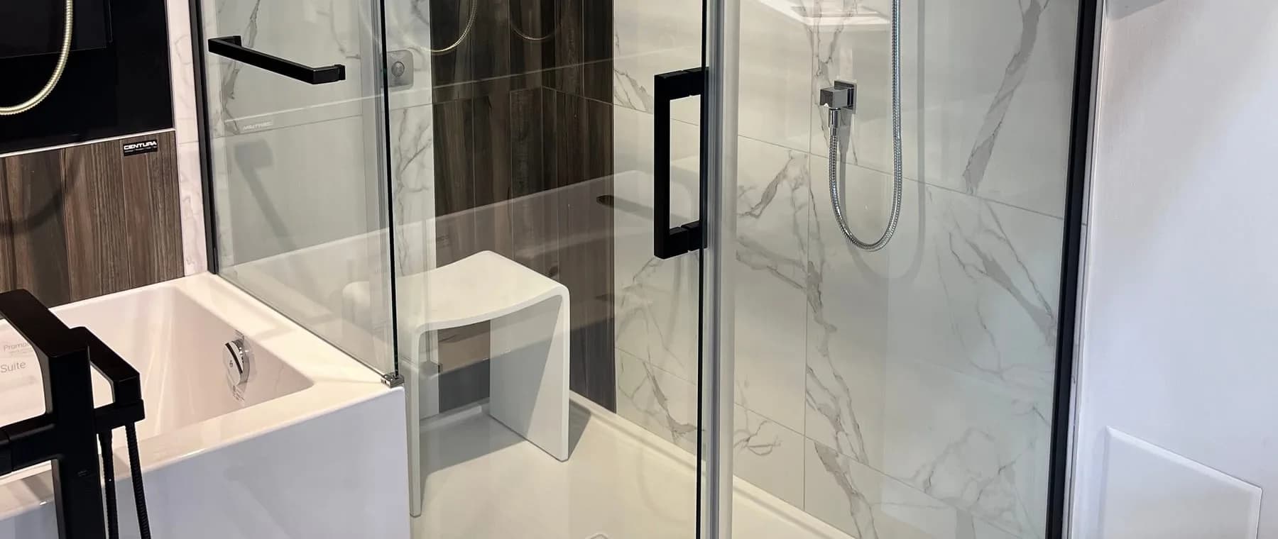 Vitre de douche coulissante, poignée noire et murs effet marbre blanc