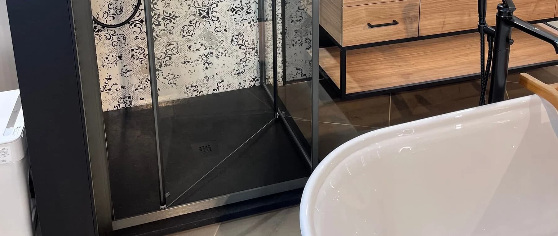 Douche à base noire, meuble-lavabo en bois et baignoire autoportante
