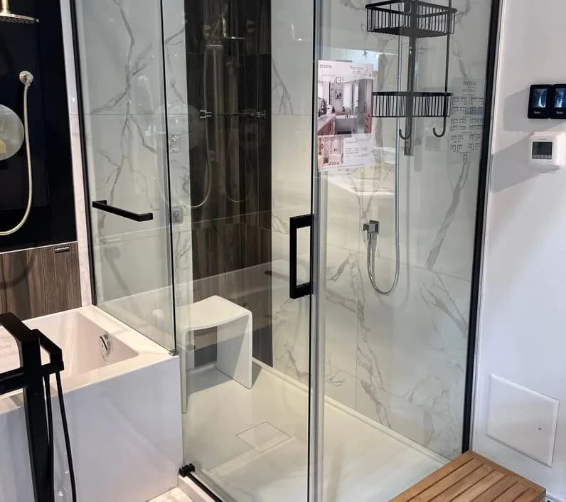 Vitre de douche coulissante et quincaillerie noire, murs effet marbre